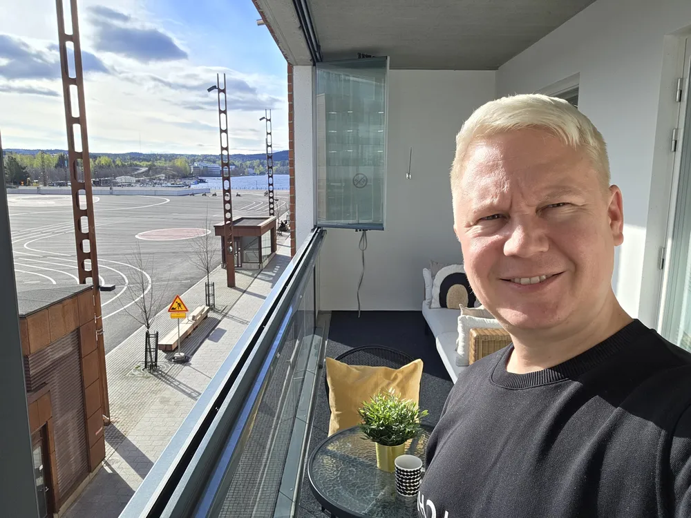 Janne Immonen on the balcony of a Lutakko apartment, Lutakko square behind